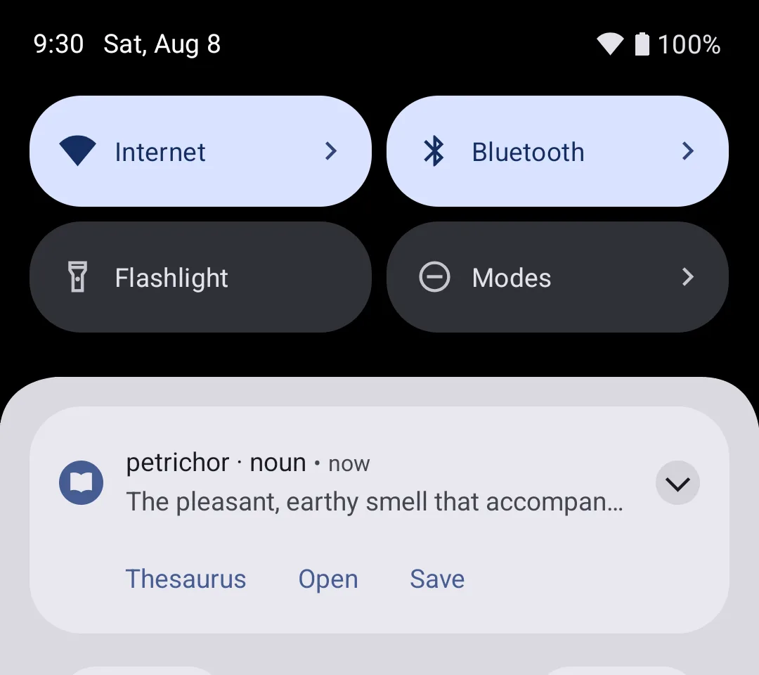 An Android notification shade showing a QuickWord notification: the headword 'petrichor' with its part of speech 'noun', the start of the definition 'The pleasant, earthy smell that accompan...', and a row of three actions reading Thesaurus, Open and Save.